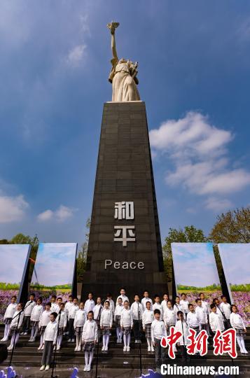 一群来自南京芳草园小学的和平宣讲小使者，抑扬顿挫地朗诵着诗人冯亦同撰写的诗歌《紫金花》。　泱波 摄